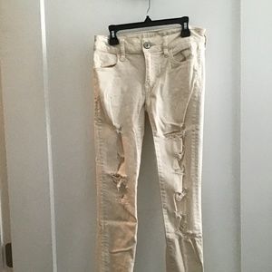 Cream colored jeans with a raw hem